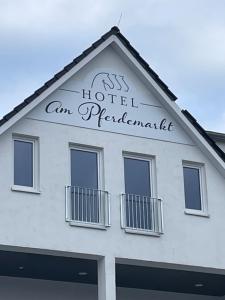 Un edificio blanco con un cartel encima. en Hotel am Pferdemarkt, en Aurich