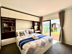a bedroom with a bed with a teddy bear on it at Modern Comfy 3 Bedrooms House in Chartwell in Hamilton