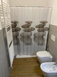 Un baño con inodoro y cortina de ducha. en Casa Piera, en Turín