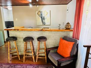 a bar with two stools and a counter with an elephant painting at Ndumu Safari Resorts in Jozini