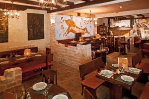 a restaurant with wooden tables and a dinosaur on the wall at Bluesun Hotel Borak in Bol