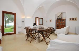 a dining room with a wooden table and chairs at Masseria Autigne in Otranto