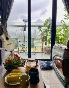 einen Tisch mit einer Platte Mais und einer Gitarre in der Unterkunft Châu Gia homestay in Thôn Văn Dương