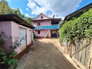 una casa con una valla frente a un patio en Dhankuta Community Homestay - Sipting, en Dhankutā