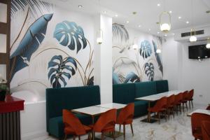 a dining room with tables and chairs and a wall with plants at Cromwell Hotel in London