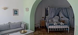 una camera con letto a baldacchino e divano di Solaris a Chora Folegandros