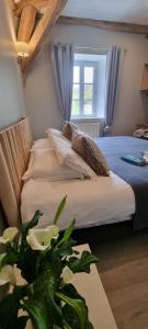 a bedroom with a bed with a plant on a table at L'Annexe du Moulin Renaudiots in Autun +71 photos