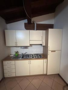 a small kitchen with white cabinets and a sink at Dante 10 Flat in Cremona +6 photos