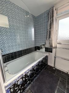 Una bañera en un baño con azulejos azules. en Carpe Diem - Portland Retreat, en Portland