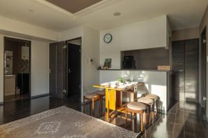 a kitchen with a table with chairs and a clock on the wall at Cozy Stay Sapporo Hongodori 1005 in Sapporo