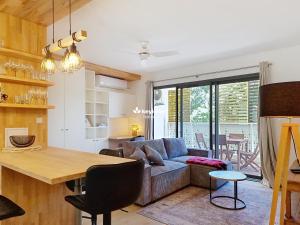 una sala de estar con un sofá y una mesa en Ecrin Salé - T2 rénové de 64 m2 - Etang-Salé, en Étang-Salé