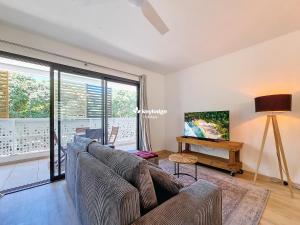 una sala de estar con un sofá y una mesa en Ecrin Salé - T2 rénové de 64 m2 - Etang-Salé, en Étang-Salé