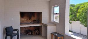 a brick fireplace with a sink and a window at AHA Pet Friendly cottage in Agulhas