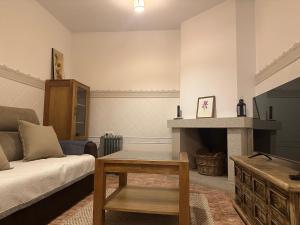 a living room with a bed and a fireplace at Veratha House in Candeleda