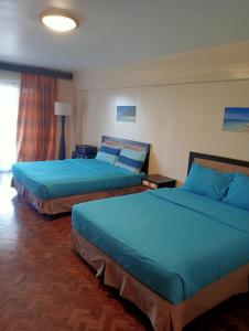 2 letti in camera d'albergo con lenzuola blu di Alta Vista de Boracay Blank 209 a Boracay Altre 2 foto