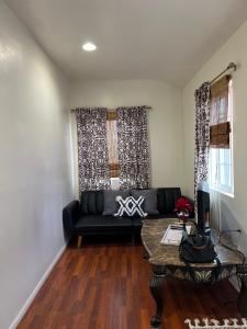 a living room with a black couch and a table at Jacob Unit-C in Hawthorne