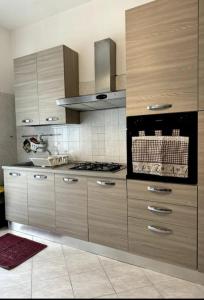 eine Küche mit Holzschränken und einem Herd in der Unterkunft A Crema da Nicola&Laura troverete Comfort e Relax in Crema