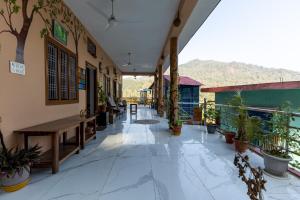 a corridor of a building with potted plants at The Corbett Rajae Homestay in Badīyārgaon