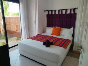 a bedroom with a large bed with a purple headboard at Villa Eden Dyar Shemsi L'Orangeraie Agadir in Taroudant +25 photos