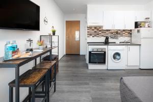 kuchnia z białymi urządzeniami i blatem ze stołem w obiekcie Casa Zoe - Apartamentos en Suite Budha - Buenas vibras! Edificio #LasNaciones w mieście Benalmádena
