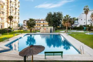 basen z ławką i parasolem w obiekcie Casa Zoe - Apartamentos en Suite Budha - Buenas vibras! Edificio #LasNaciones w mieście Benalmádena