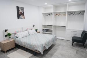 un dormitorio con una cama y una silla en Apart LA PLANA II, en Castellón de la Plana