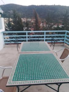 un banco verde en la parte superior de un balcón en L'ile de caroubier, en Taounate
