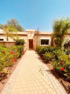 a walkway in front of a house with flowers at Villa Eden Dyar Shemsi L'Orangeraie Agadir in Taroudant