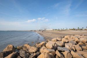 a beach with rocks in the water and a beach w obiekcie AS22947-Studio cabine résidence direct sur plage w mieście Le Grau-du-Roi