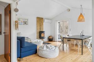 a living room with a blue couch and a table at Charming Cottage In Raageleje in Vejby +21 photos