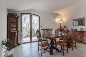 Un comedor con mesa y sillas de madera. en Casetta dei Daini, en Orio al Serio