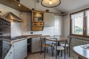 a kitchen with a table and chairs and a stove at Casetta dei Daini in Orio al Serio