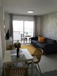 un soggiorno con un divano, un tavolo e delle sedie di KC home abroad a Playa de las Americas