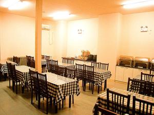 a restaurant with tables and chairs in a room at GreenTree Inn HeBei QinHuangDao ChangLi County MinSheng Road Walking Street Express Hotel in Changli