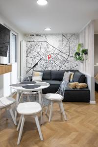 a living room with a couch and a table and chairs at Sekwoja Rent - Malmeda 15 in Białystok