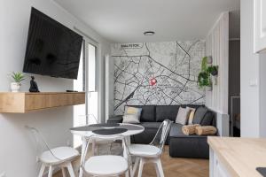 a living room with a couch and a table and chairs at Sekwoja Rent - Malmeda 15 in Białystok