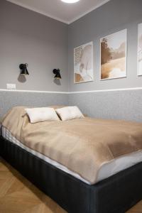 a bed in a bedroom with pictures on the wall at Sekwoja Rent - Malmeda 15 in Białystok +27 photos