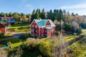 an aerial view of a large red house with a green roof at Åbergs Gård - BnB Orsa Åberga in Kallmora