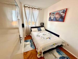a small bedroom with a bed and a window at Lea - sea&city view Apartment with Terrace in Dubrovnik