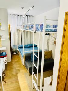 a dorm room with two bunk beds and a couch at Balai Nami in Pajak