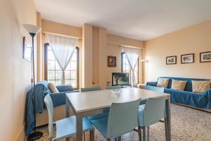 un soggiorno con tavolo, sedie e divano di Giudecca Elegant APT with Stunning Lagoon View! a Venezia