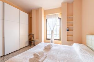 una camera da letto con un letto con asciugamani sopra di Giudecca Elegant APT with Stunning Lagoon View! a Venezia