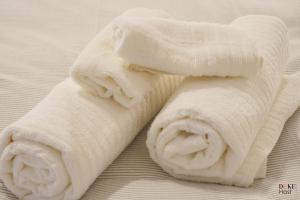 een rol witte handdoeken op een bed bij CH 5Torres in Madrid