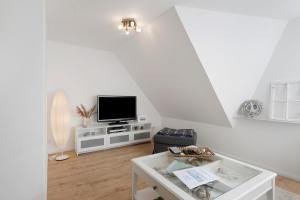 soggiorno con TV su un armadietto bianco di Ferienwohnung Auszeit a Nordstrand