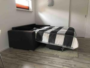 ein Schlafzimmer mit einem Bett mit einer schwarz-weißen Bettdecke in der Unterkunft small&fine in Stockach