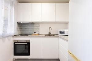 una cucina bianca con un lavello e un forno a microonde di Home2Book Cozy Coastal Duplex & Pool, Caletillas a Punta Larga
