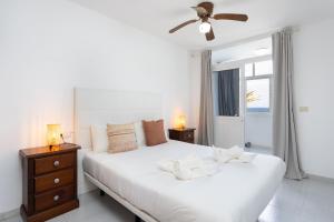 una camera da letto bianca con un letto e una finestra di Home2Book Cozy Coastal Duplex & Pool, Caletillas a Punta Larga Altre 25 foto
