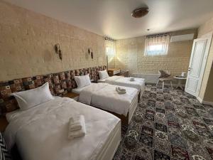 a room with three beds in a room at AL MARYAM HoteL in Samarkand
