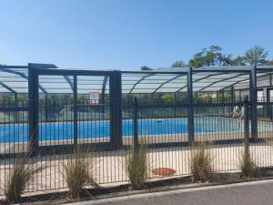 a swimming pool behind a fence with a pool at Chalet ARZAL in Arzal