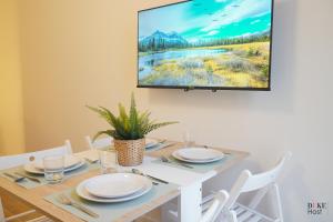 een witte eettafel met een tv aan de muur bij CH 5Torres in Madrid